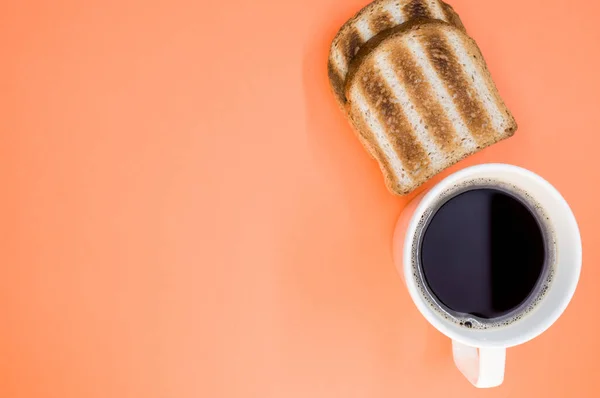 Tiro Ângulo Alto Uma Xícara Café Torradas Uma Superfície Laranja — Fotografia de Stock