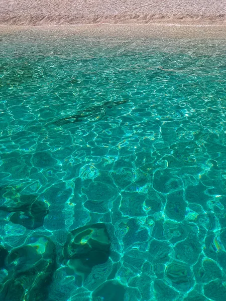 砂浜がある天然のターコイズブルーの水の垂直ショット 背景に最適です — ストック写真