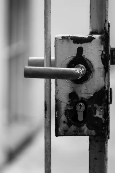 門のドアロックの垂直グレースケールショット — ストック写真
