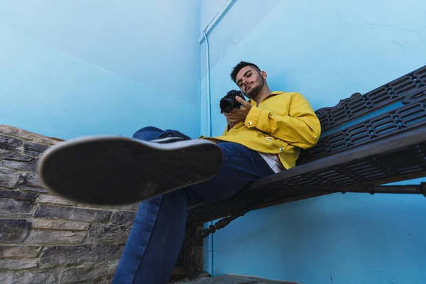 Macho Usando Cámara Mientras Está Sentado Junto Una Pared Azul — Foto de Stock