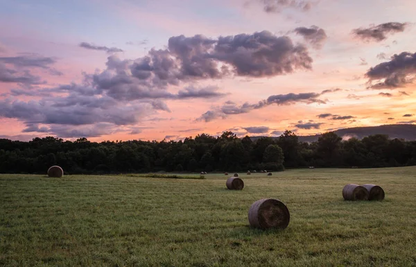 Nyvalsade Höbalar Vilar Böljande Kulle Med Dramatiska Molnlandskap Vid Soluppgången — Stockfoto