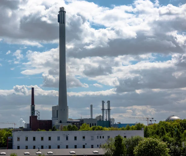 雲に覆われた劇的な空の前に長い煙突を持つ複合火力発電所の眺め — ストック写真