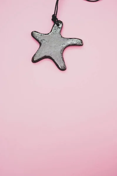 Μια Κάθετη Φωτογραφία Του Αστερία Μενταγιόν Απομονώνονται Ένα Ροζ Φόντο — Φωτογραφία Αρχείου
