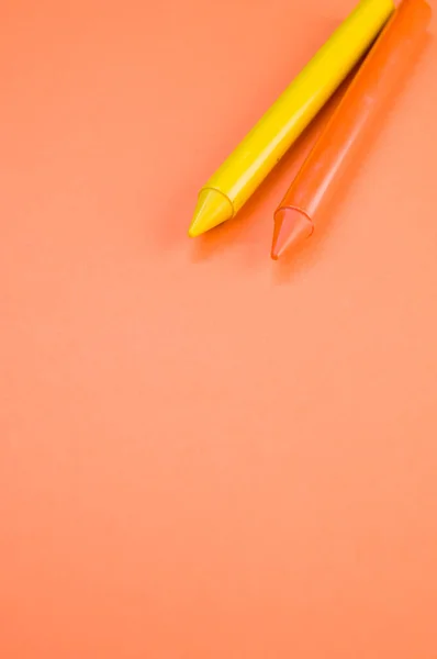 Eine Vertikale Aufnahme Von Zwei Buntstiften Auf Orangefarbener Oberfläche — Stockfoto