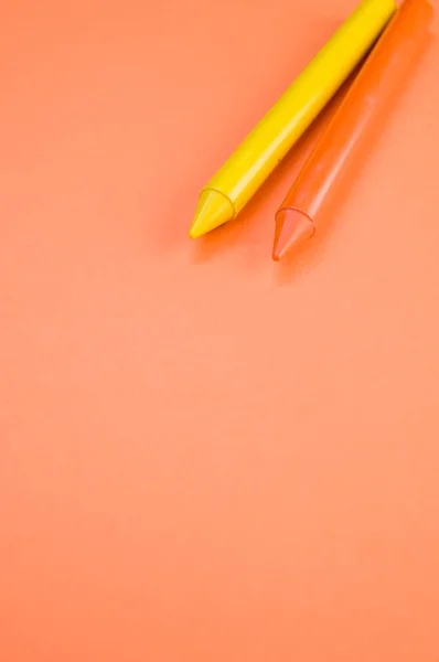 Een Verticaal Shot Van Twee Krijtjes Een Oranje Oppervlak — Stockfoto