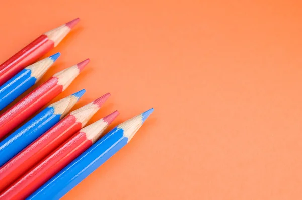 Eine Hochwinkelaufnahme Von Roten Und Blauen Bleistiften Auf Roter Oberfläche — Stockfoto