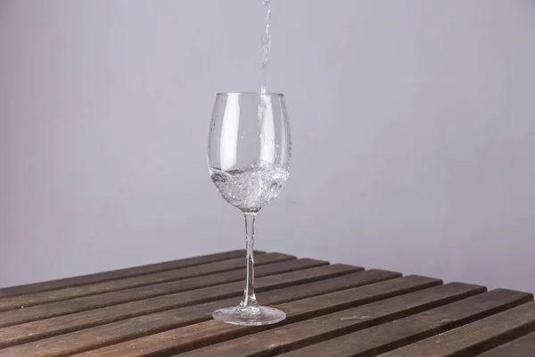 Calice Cristallo Tavolo Legno Che Riempie Con Acqua Sfondo Bianco — Foto Stock