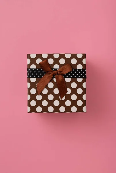 Een Bruine Polkadot Geschenkdoos Roze Achtergrond — Stockfoto