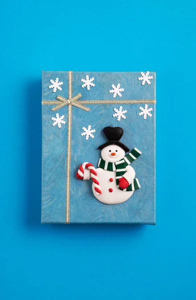 Ένα Μπλε Κουτί Δώρου Χριστουγέννων Διακοσμημένα Ένα Χιονάνθρωπο Και Νιφάδες — Φωτογραφία Αρχείου