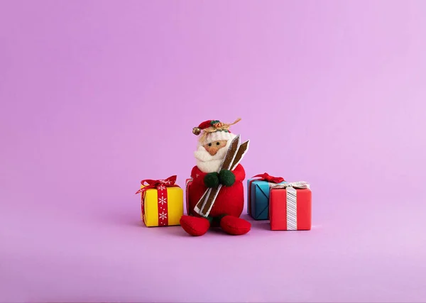 Closeup Cute Santa Claus Toy Colorful Gift Boxes Purple Background — Stock Photo, Image