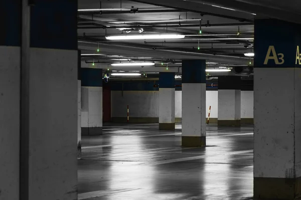 有照明和白色柱子的地下停车场 — 图库照片