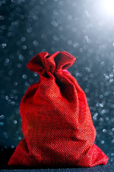 サンタクロースの赤いバッグとギフトクリスマスの光沢のある背景 — ストック写真