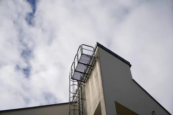 曇った空に対して背の高い建物の緊急出口はしごの低角度ショット — ストック写真