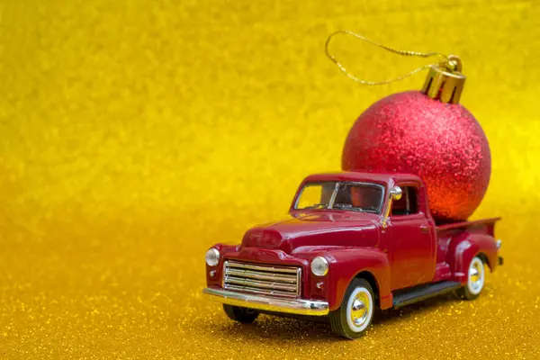 Retro Toy Car Carries Christmas Red Ball Shiny Yellow Background — Stock Photo, Image