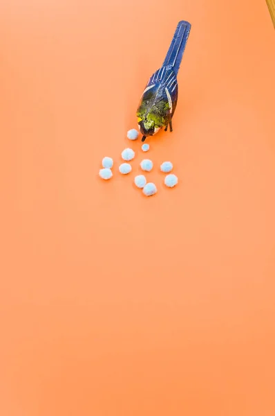 Вертикальный Снимок Маленькой Раскрашенной Вручную Птицы Ватными Шариками Оранжевом Фоне — стоковое фото