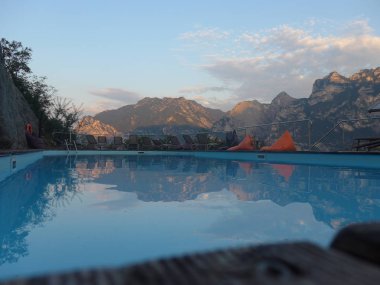 Şezlonglu açık teras ve dağ manzaralı havuz