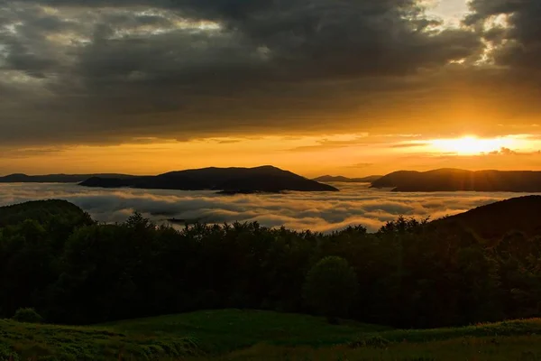 Beautiful sunrise in ukrainian mountains with mist in the valley