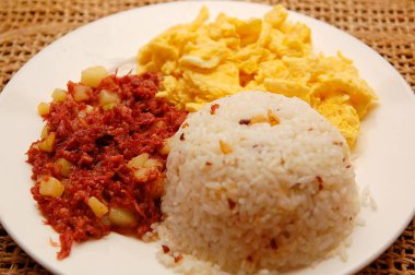 Kahvaltı, otelde servis edilen sarımsaklı pirinç, omlet ve konserve sığır etinden oluşur.