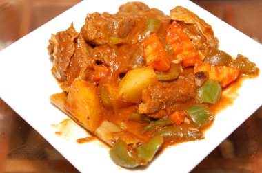 Akşam yemeği için domates soslu biftek tabakta servis edilir.