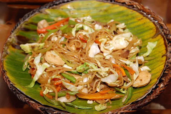 Pancit noodles with mixed vegetables for dinner served in banana leaf plate