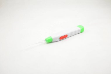 Kirli kulak kirini çıkarmak için ışık ve plastik kazmalı el feneri kulaklığı kullanılıyor.