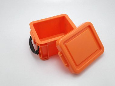 Üzerinde kapağı olan küçük bir plastik turuncu depolama kutusu ve kenar kilitleri küçük nesneleri koymak için kullanılır. 