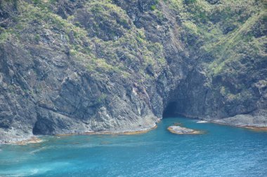 Dingalan, Aurora, Filipinler 'deki Dağ manzaralı beyaz sahil beldesinde kaya oluşumu ve deniz suyu