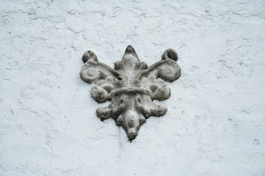 Beyaz duvar kaplama eğrisi dizayn amblemi evin dışına yerleştirilmiş.