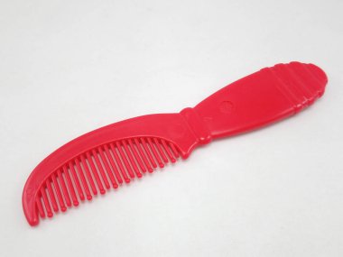 Kırmızı çocuk tarağı ve kısa sapı saçı düzgün ve düz göstermek için kullanılır.