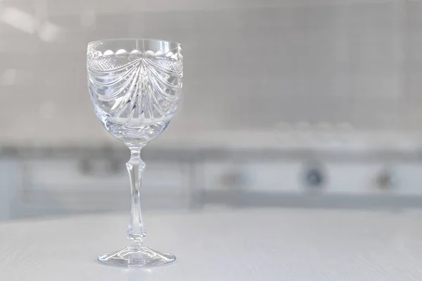 vintage crystal glass with engraving on a white moan against the background of the kitchen in classic design