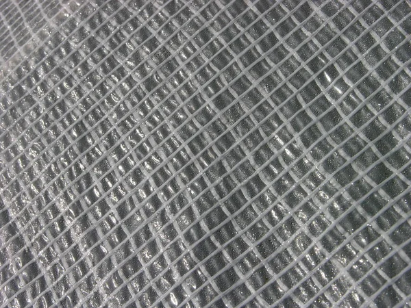 聚乙烯增强膜表面具有各种形状的太阳眩光 揭示了薄膜的质地 薄膜的背面覆盖着冷凝水 — 图库照片