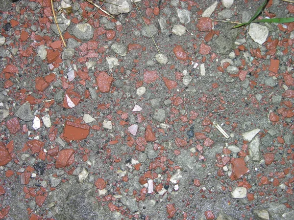 ıslak ezilmiş tuğla ıslak beton üzerinde ince kırıntıları içine ışık vurgular bir su birikintisi yansıyan. yağmur yağdıktan sonra.