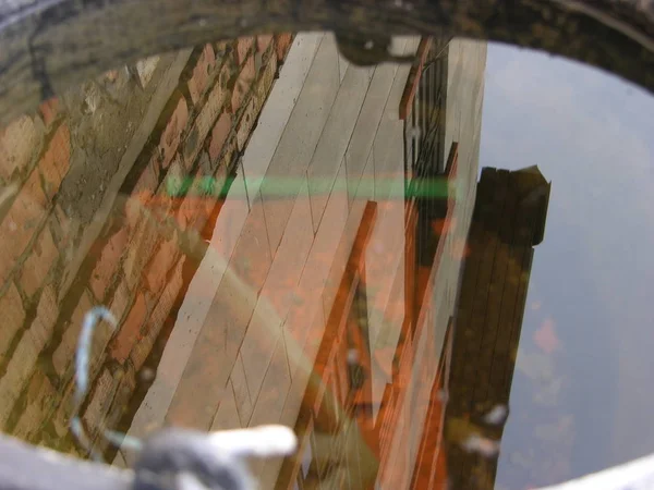 Windows, çatı, gökyüzü ile su duvarı bir kova yansıması.