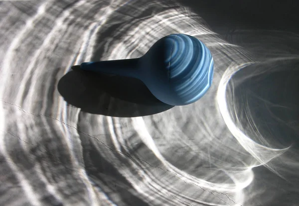 Romantik gölgeler ve ışık düşük kirişler (antitez bir tür) şeffaf bir vazo parlama arka planda Prosaic tıbbi enema armut. Sığ odakla farklı açılarda çekim.