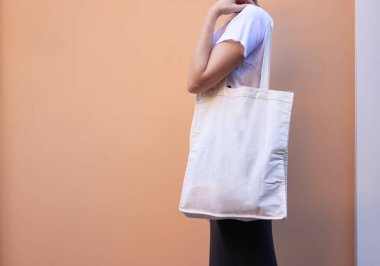 Boş beyaz alışveriş tuvali. Kumaş poşet kadın elinde.