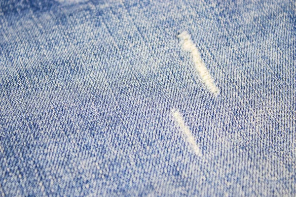 Förstörd i tvättblå jeans. isolerad bakgrund — Stockfoto