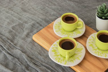 Tahta üzerinde duran Türk kahvesi. Arka planda gri kapak