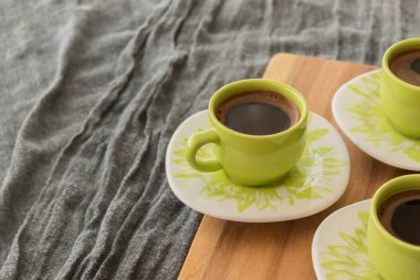 Tahta üzerinde duran Türk kahvesi. Arka planda gri kapak