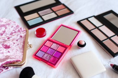 Makyaj çantalı ve kozmetik ürünlü makyaj paletlerini beyazın üzerine kapat. 