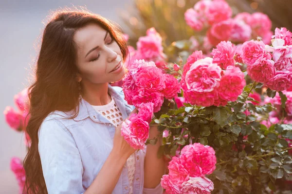 Gülümseyen Güzel Bir Kadın Yaşlarında Bahçedeki Pembe Gülleri Kokluyor Yaz — Stok fotoğraf