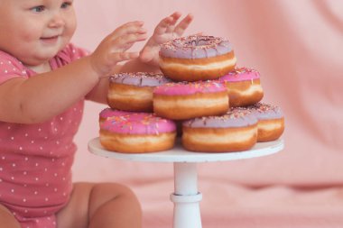 Lezzetli donutlar küçük kızla yakın plan çekimde hazır bekliyor. Ellere odaklan. Çocukluk. 