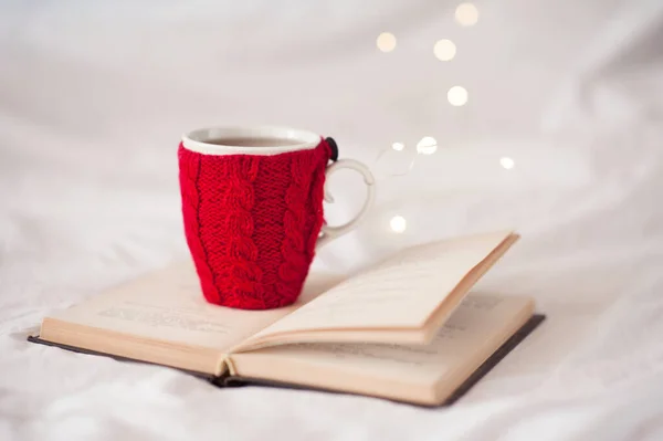 Симпатичная Чашка Кофе Красным Вязаным Текстилем Стоящая Открытой Книге Над — стоковое фото