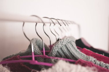 Kış kıyafetleri örülü elbise askıları. Yakın plan. Seçici odak. 