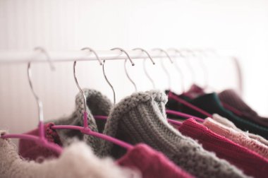 Dükkandaki askılarda örgü süveterler asılı. Seçici odak. 