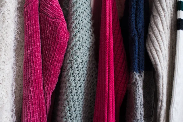 Örgü giysiler mağazada askıda asılı duruyor. Kış mevsimi. 