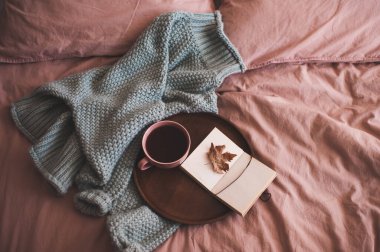 Bir fincan taze kahve ya da çay, açık çizim kitabı, ahşap tepside düşmüş sonbahar yaprağı ve yatakta örülmüş süveter. Günaydın.. 