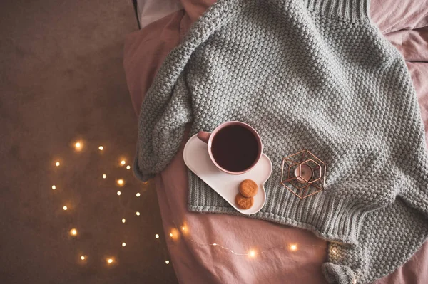 クリスマスの輝くライトの上にクッキーやキャンドルと新鮮な紅茶やコーヒーとニットセーターを閉じます おはようございます 朝食の時間 — ストック写真