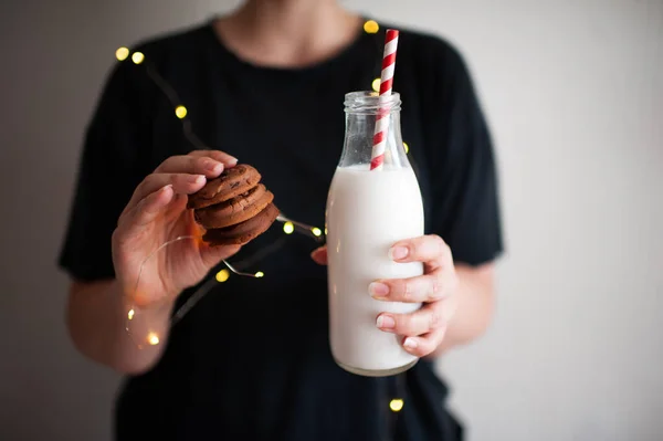 女人拿着美味的饼干和一瓶鲜牛奶在明亮的灯光下关上了门 寒假季节 早上好 — 图库照片