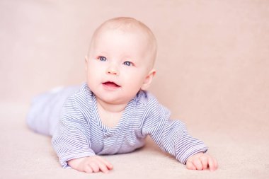 Gülümseyen bebek yatakta uzanıyor. Çocukluk. 