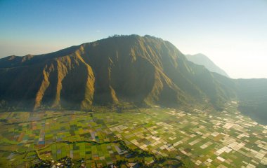 Güzel pirinç tarlaları Sembalun Köyleri 'nin üzerinde sabah güneşiyle Lombok adasının üzerinde uçuyor. Yeşil alan ve Panorama Tepesi
